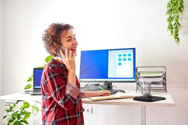Kvinde taler i mobiltelefon på sit kontor